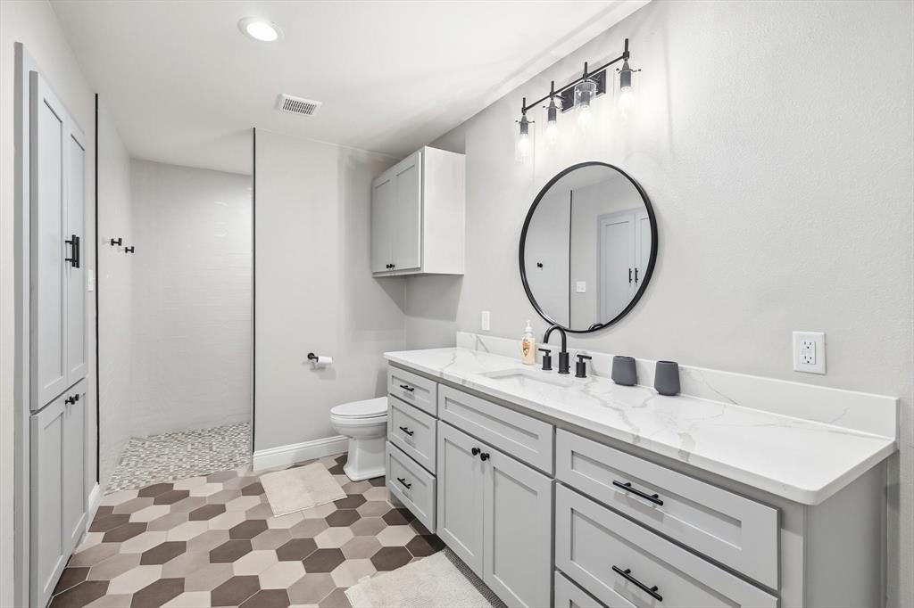 4433 Chapel Road Graham, TX 76450 - Photo 22 of 32 a bathroom with a granite countertop sink mirror and a toilet