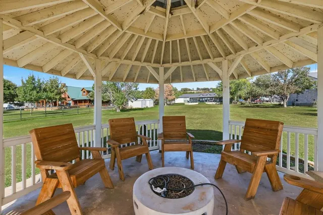 a patio with water view fountain with table and chairs under an umbrella
