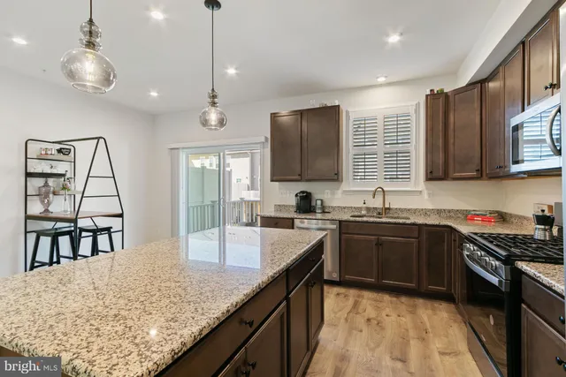a kitchen with stainless steel appliances granite countertop sink stove top oven and microwave