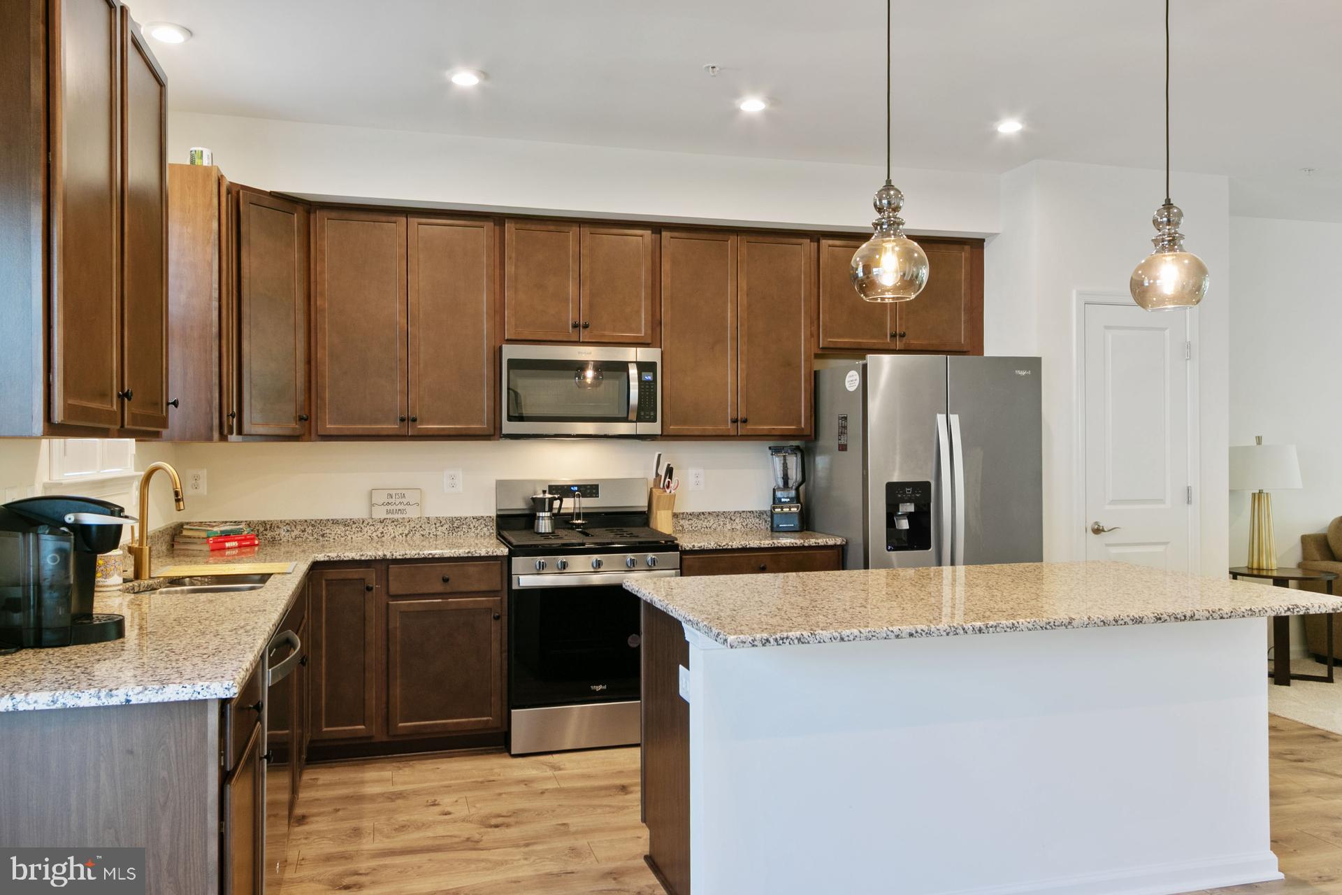 340 Shipyard Drive Cambridge, MD 21613 - Photo 14 of 35 a kitchen with stainless steel appliances granite countertop a sink a stove top oven a refrigerator cabinets and wooden floor