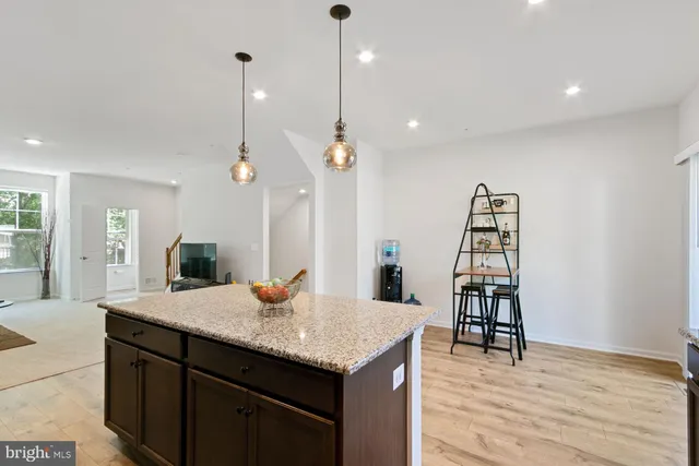 a kitchen with a sink a center island and wooden floor