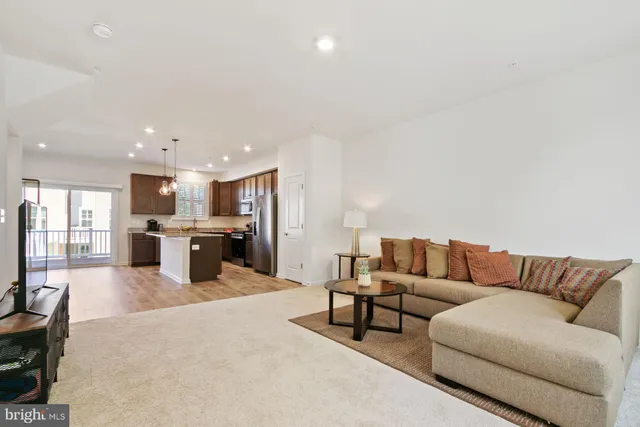 a living room with furniture kitchen view and a couch