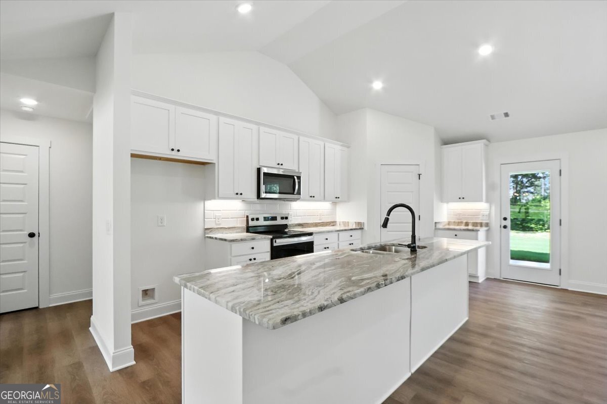 166 Rachel Lane Hartwell, GA 30643 - Photo 12 of 51 a kitchen with stainless steel appliances granite countertop a sink a stove a refrigerator cabinets and a wooden floor