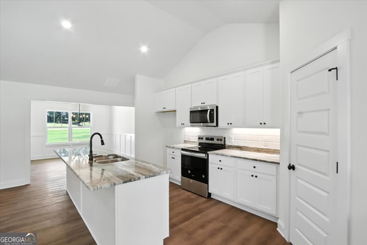 166 Rachel Lane Hartwell, GA 30643 - Photo 15 of 51 a kitchen with stainless steel appliances granite countertop a stove top oven a sink a counter space and cabinets