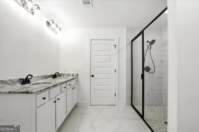 a bathroom with a granite countertop sink a shower and a mirror