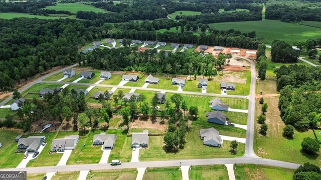 an aerial view of a house with a yard and lake view in back