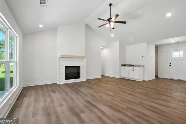 a an empty room with wooden floor and a fireplace
