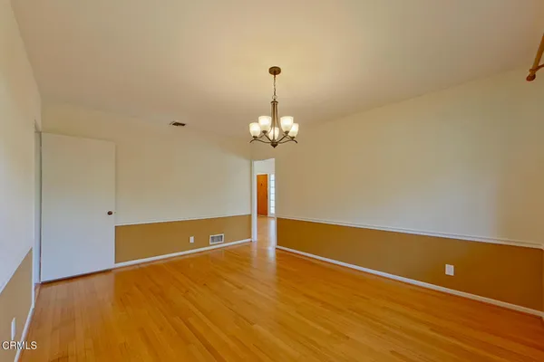 a view of a room with wooden floor and chandelier