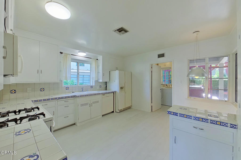 1462 Glengarry Road Pasadena, CA 91105 - Photo 13 of 57 a large white kitchen with a stove a sink dishwasher and a refrigerator