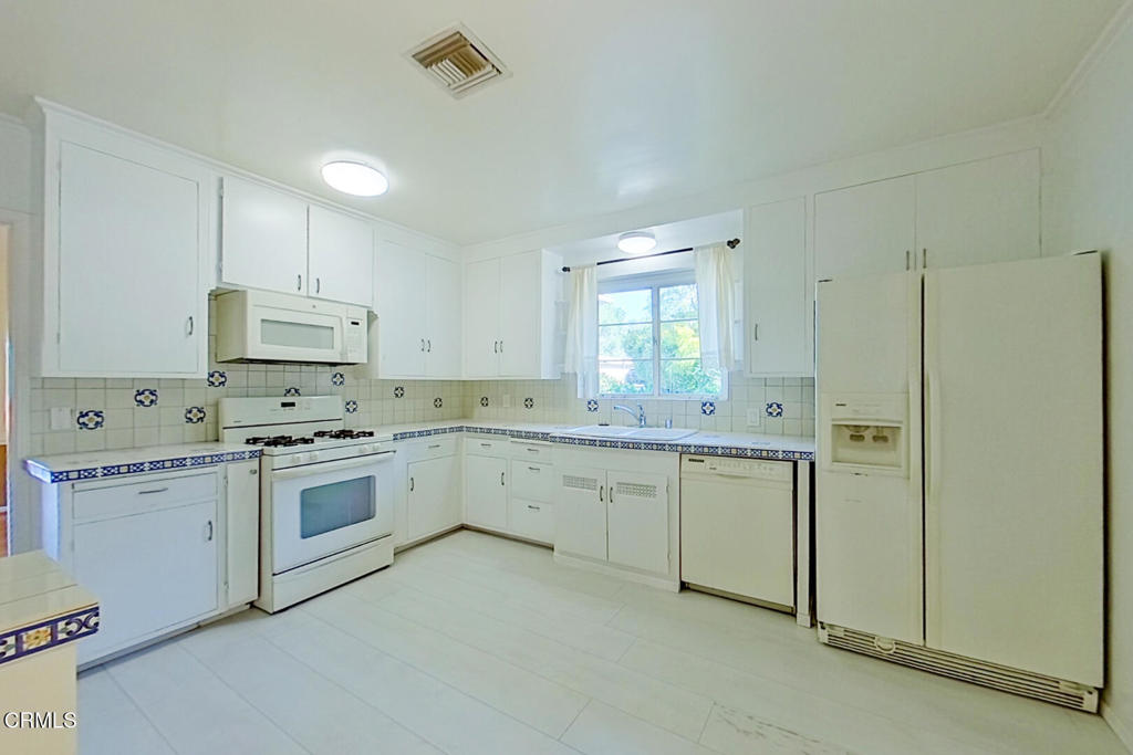 1462 Glengarry Road Pasadena, CA 91105 - Photo 17 of 57 a kitchen with a sink a stove a refrigerator and white cabinets