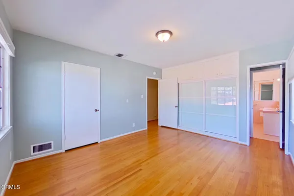 a view of an empty room with wooden floor