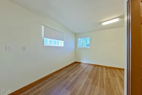 a view of an empty room with wooden floor