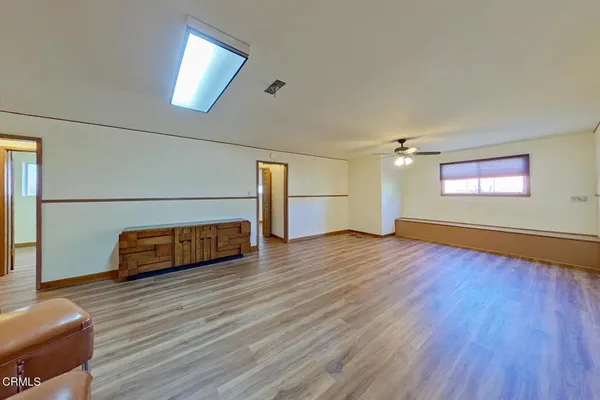 a view of a livingroom with wooden floor and a ceiling fan