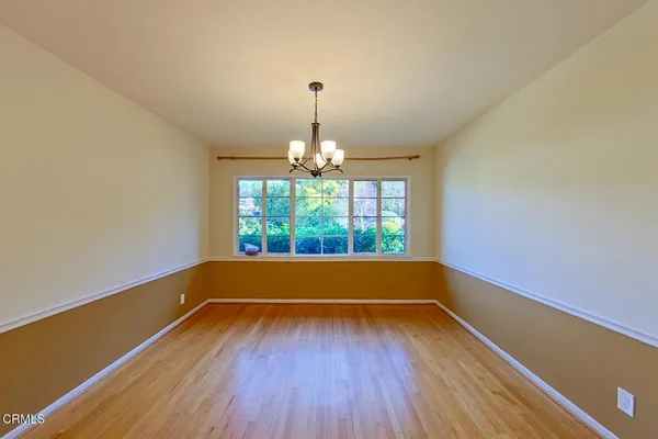 a window in an empty room with wooden floor