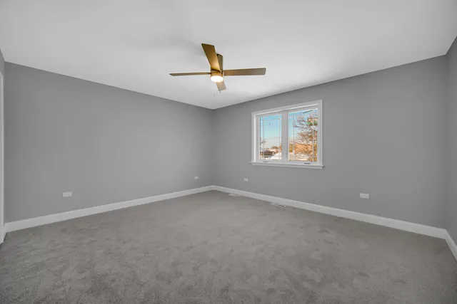 an empty room with a window and a ceiling fan