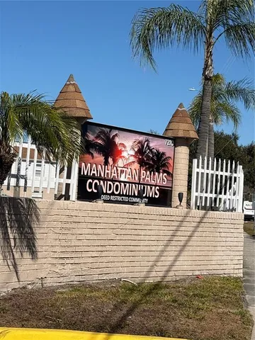 a view of a brick house with a large window and palm trees