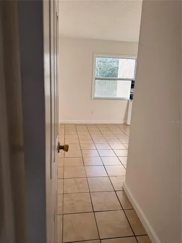 an empty room with windows and cabinet