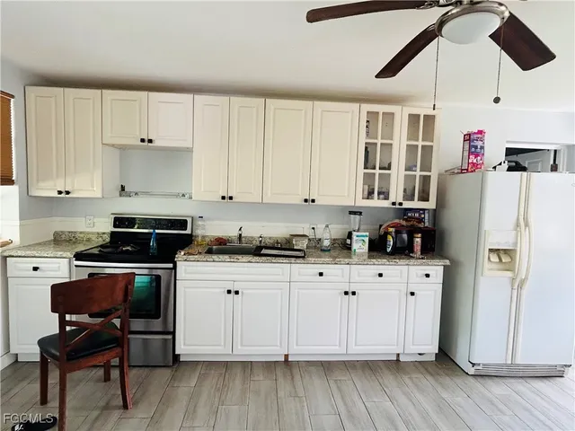 a kitchen with granite countertop white cabinets and white appliances
