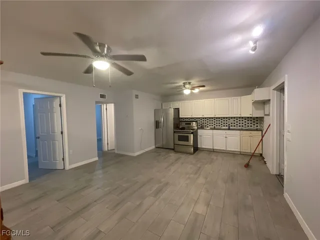 a view of an empty room with a kitchen