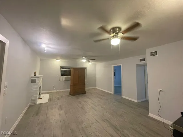 a view of a livingroom with a ceiling fan window and wooden floor