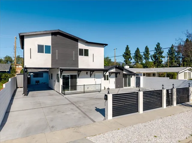 a view of a house with a balcony and yard