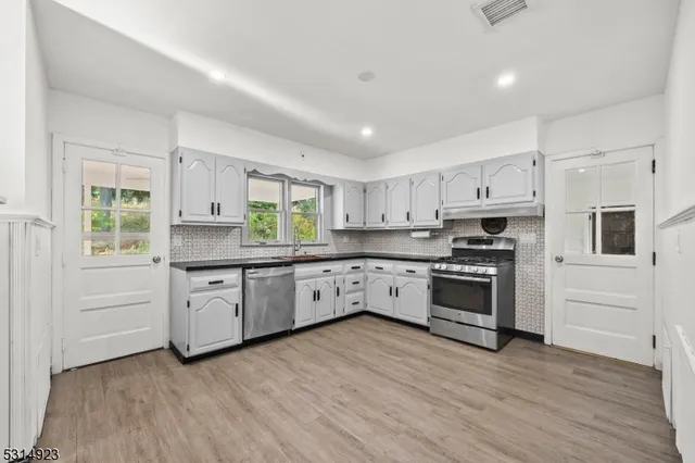 a kitchen with white cabinets and appliances