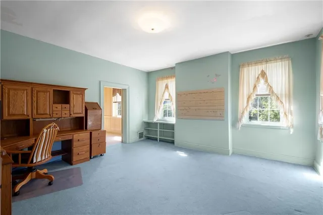 a view of a livingroom with workspace and a window