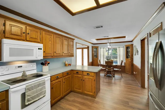 a kitchen with a sink appliances cabinets and dining table