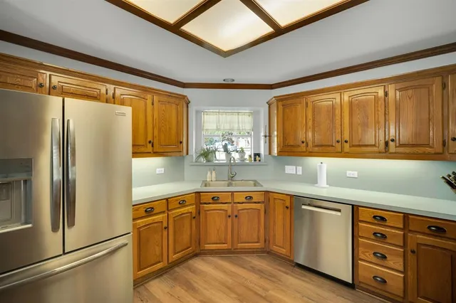 a kitchen with a sink appliances cabinets and a window