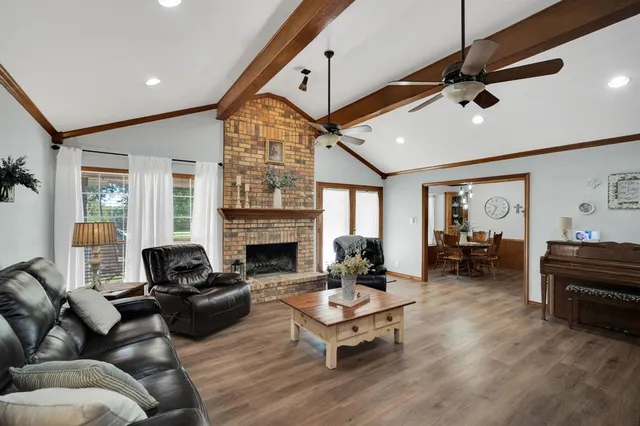a living room with furniture fireplace and a large window