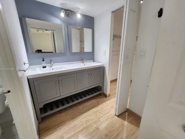 a bathroom with a double vanity sink mirror and bathtub