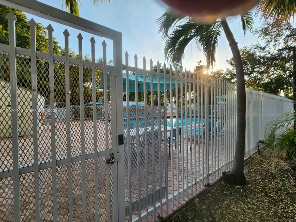 a view of a house with a small yard and palm trees