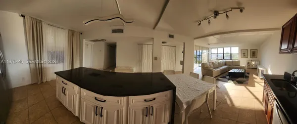 a kitchen with stainless steel appliances kitchen island granite countertop a sink and wooden cabinets