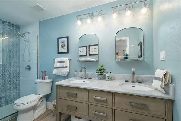 a bathroom with a double vanity sink toilet and a mirror
