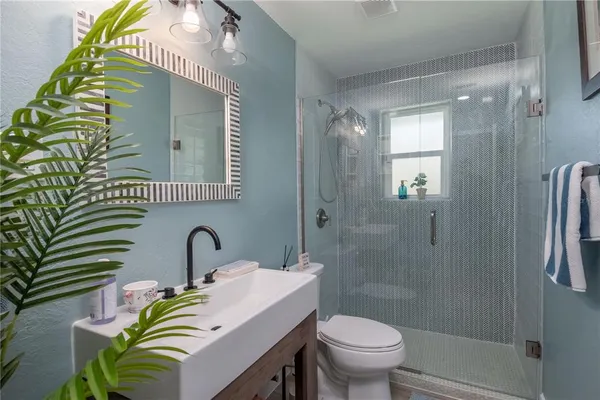 a bathroom with a sink a toilet and shower