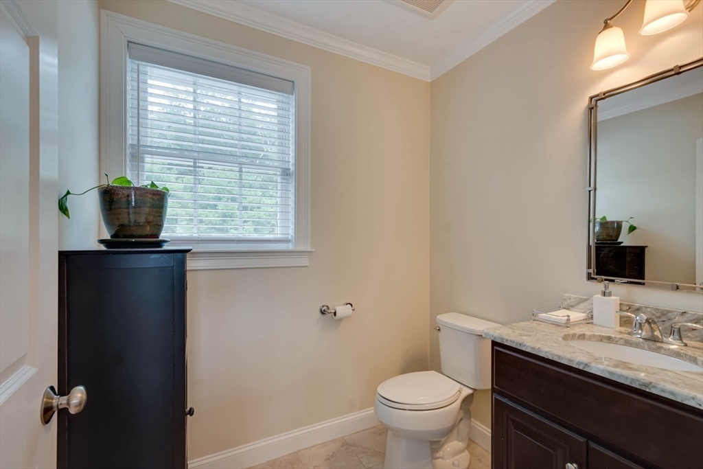 4 Rhodes Drive, Unit 4 Berlin, MA 01503 - Photo 15 of 30 a bathroom with a granite countertop toilet a sink and a mirror