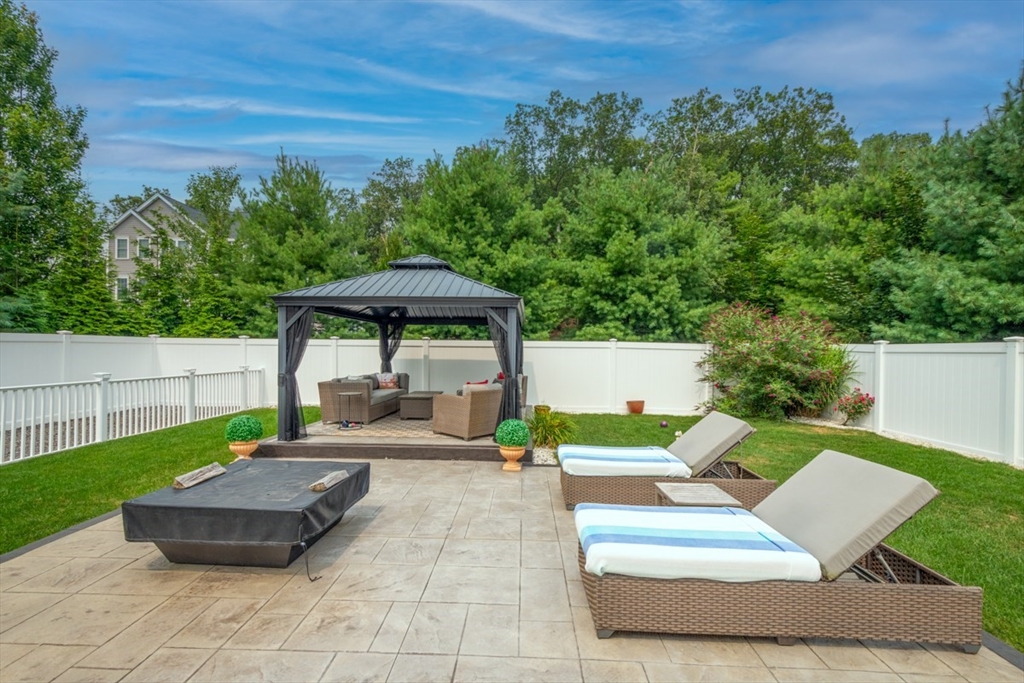 4 Rhodes Drive, Unit 4 Berlin, MA 01503 - Photo 28 of 30 a view of a patio with couches table and chairs with wooden fence and plants
