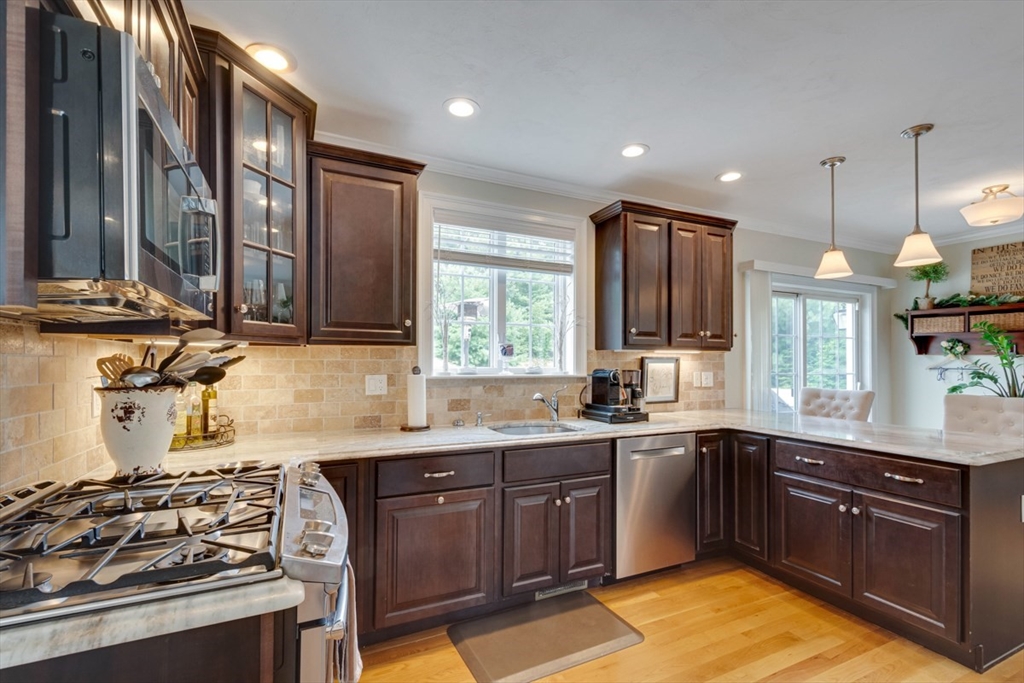 4 Rhodes Drive, Unit 4 Berlin, MA 01503 - Photo 9 of 30 a kitchen with stainless steel appliances granite countertop a sink a stove a refrigerator cabinets and wooden floor
