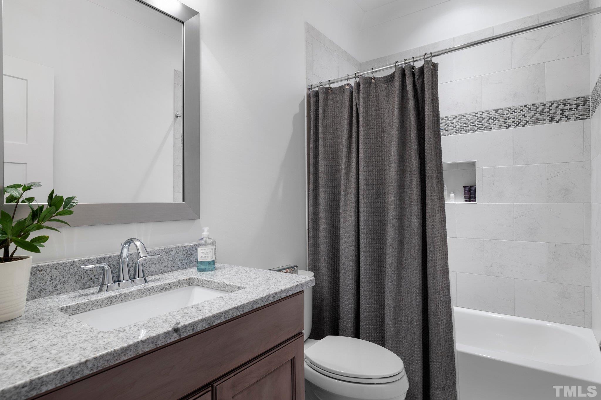 9508 Oakhurst Court Raleigh, NC 27614 - Photo 35 of 67 Granite countertop, tub/shower with custom tile surround, & tile floors.