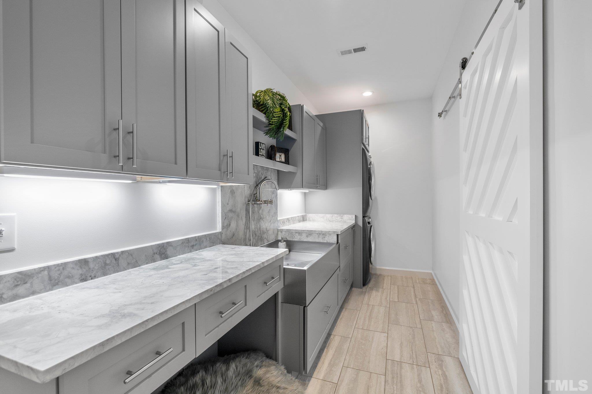 9508 Oakhurst Court Raleigh, NC 27614 - Photo 36 of 67 Gorgeous custom designed laundry, hand crafted sink, soft close cabinets & drawers, custom barn door, deep closet shelving, & quartzite countertops, & under cabinet lighting.