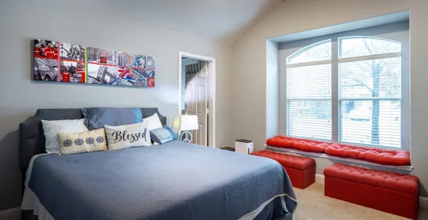 a bedroom with bed and a large window