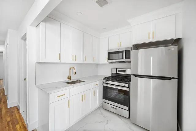 a kitchen with white cabinets and stainless steel appliances