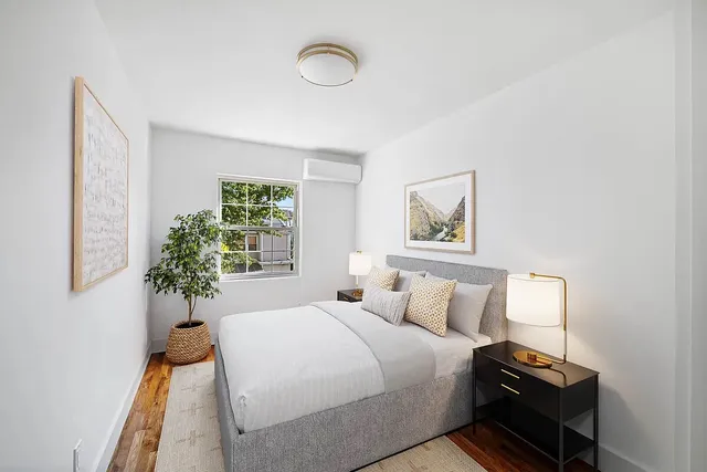 a bedroom with a bed and a lamp next to a window