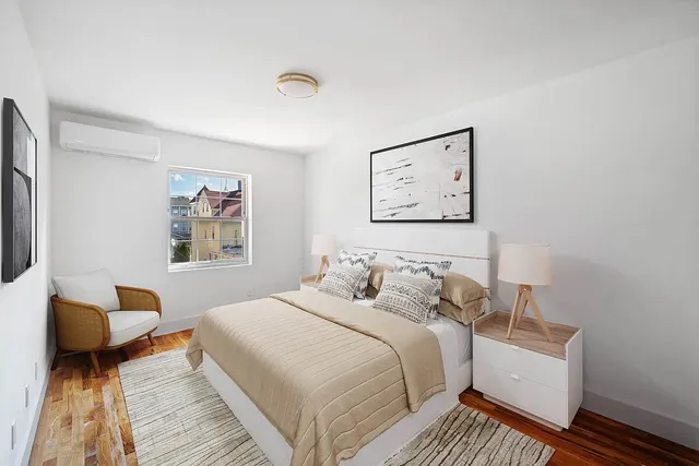 a bedroom with a bed and a painting on the wall