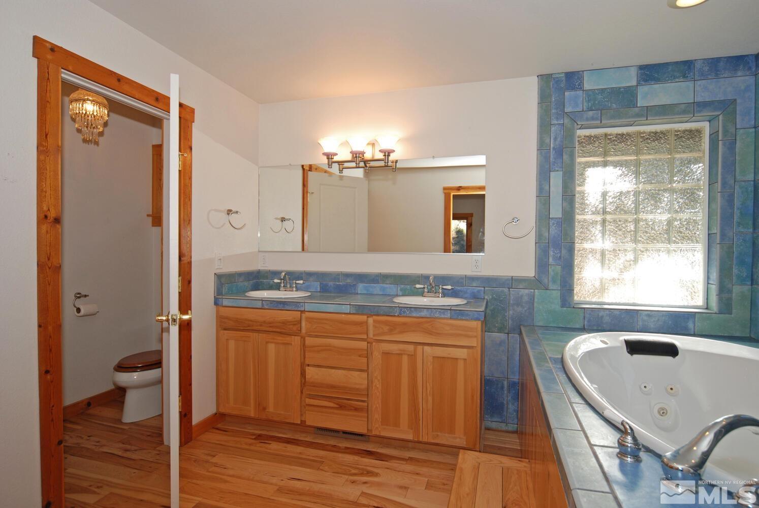 125 Pleasant Valley Road Markleeville, CA 96120 - Photo 26 of 36 a bathroom with a granite countertop sink a toilet and mirror