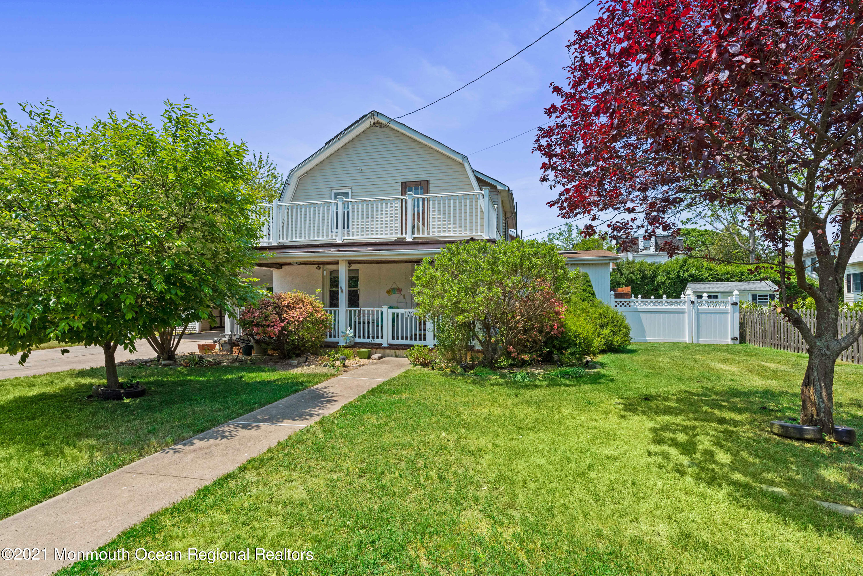 a front view of a house with a yard and trees
