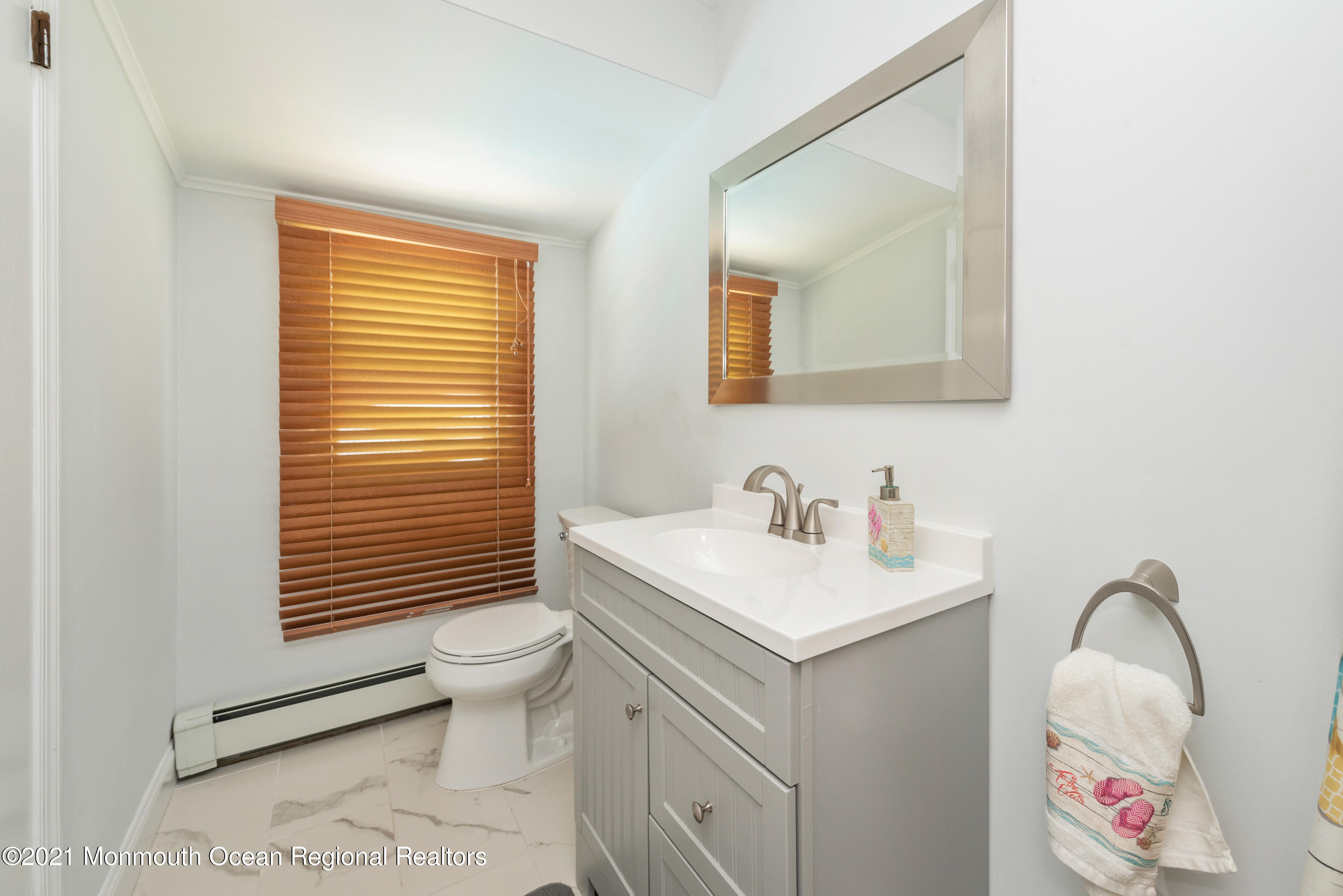 1709 Brighton Lane, Unit WINTER 2324 Spring Lake, NJ 07762 - Photo 17 of 27 a bathroom with a sink vanity mirror and toilet