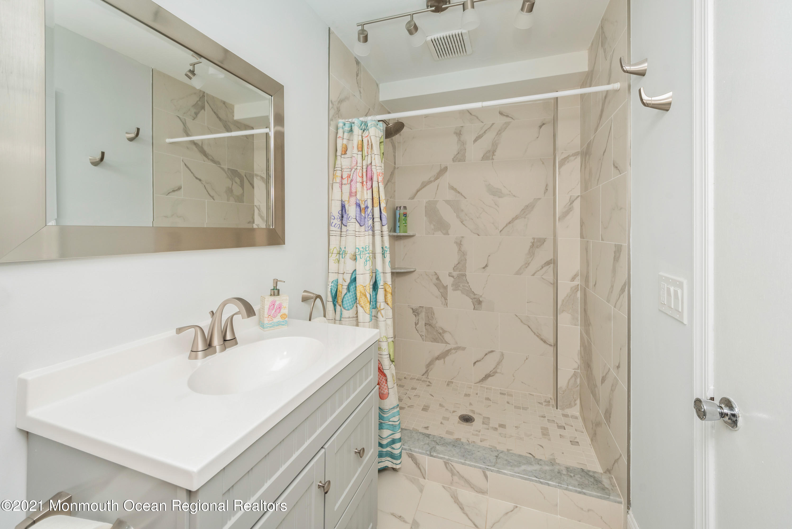 1709 Brighton Lane, Unit WINTER 2324 Spring Lake, NJ 07762 - Photo 18 of 27 a bathroom with a sink mirror and a shower