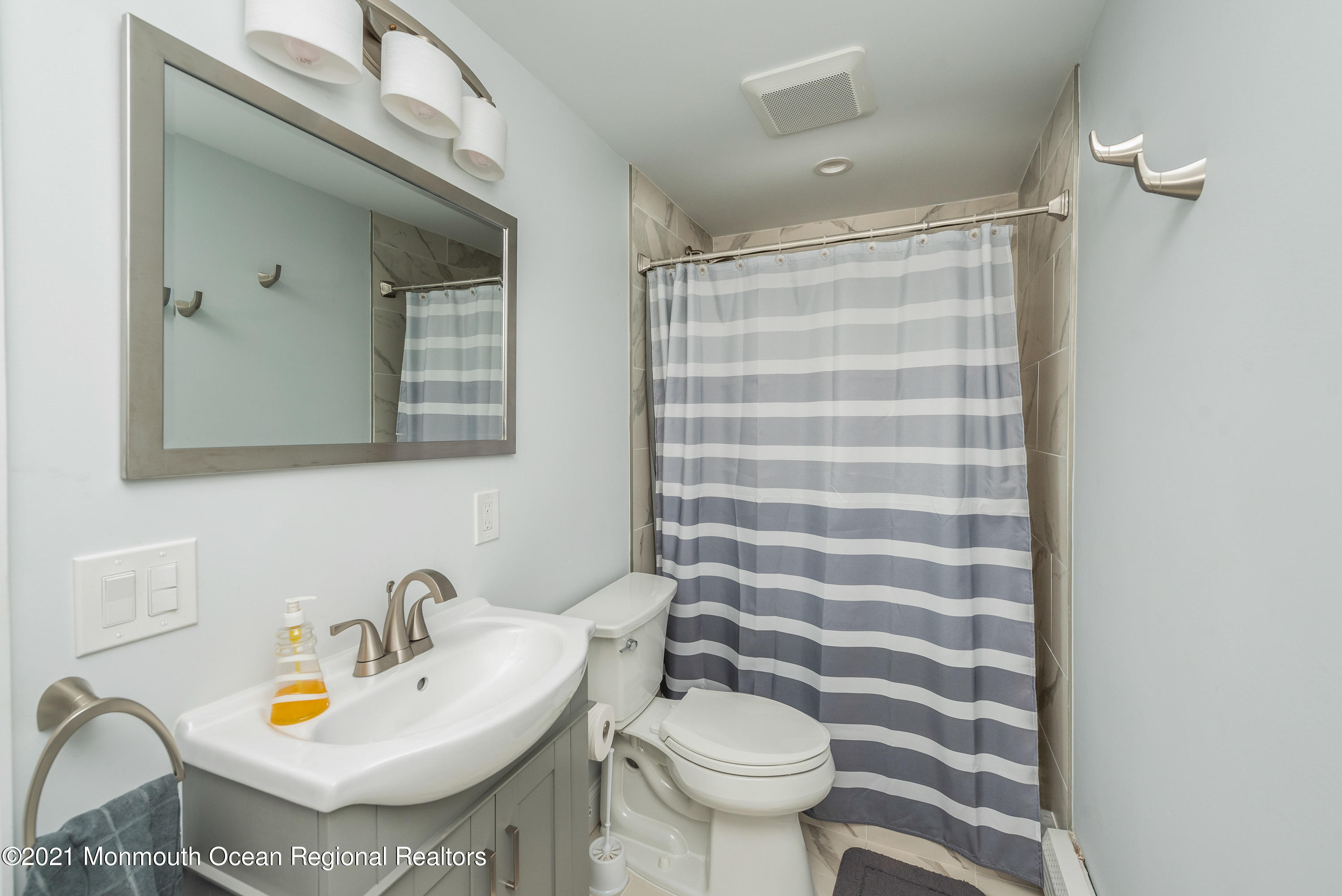 1709 Brighton Lane, Unit WINTER 2324 Spring Lake, NJ 07762 - Photo 19 of 27 a bathroom with a sink toilet and mirror
