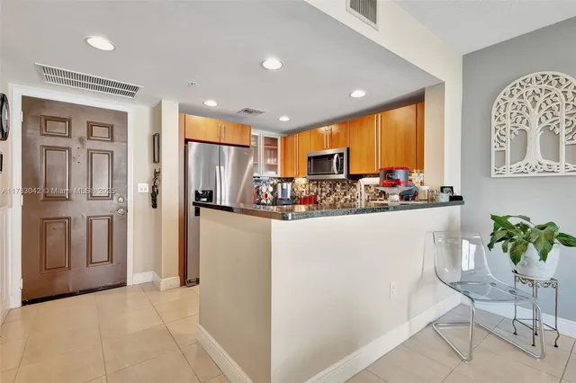 a kitchen with stainless steel appliances granite countertop a refrigerator and a stove top oven